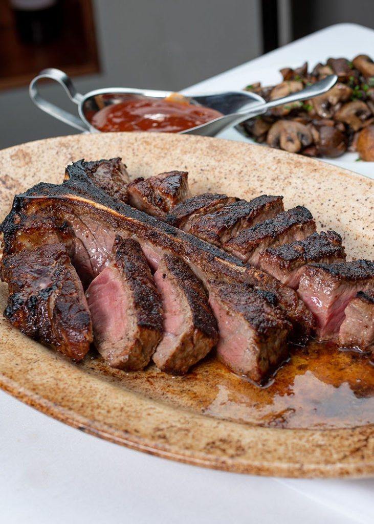 Sliced steak on a beige plate.
